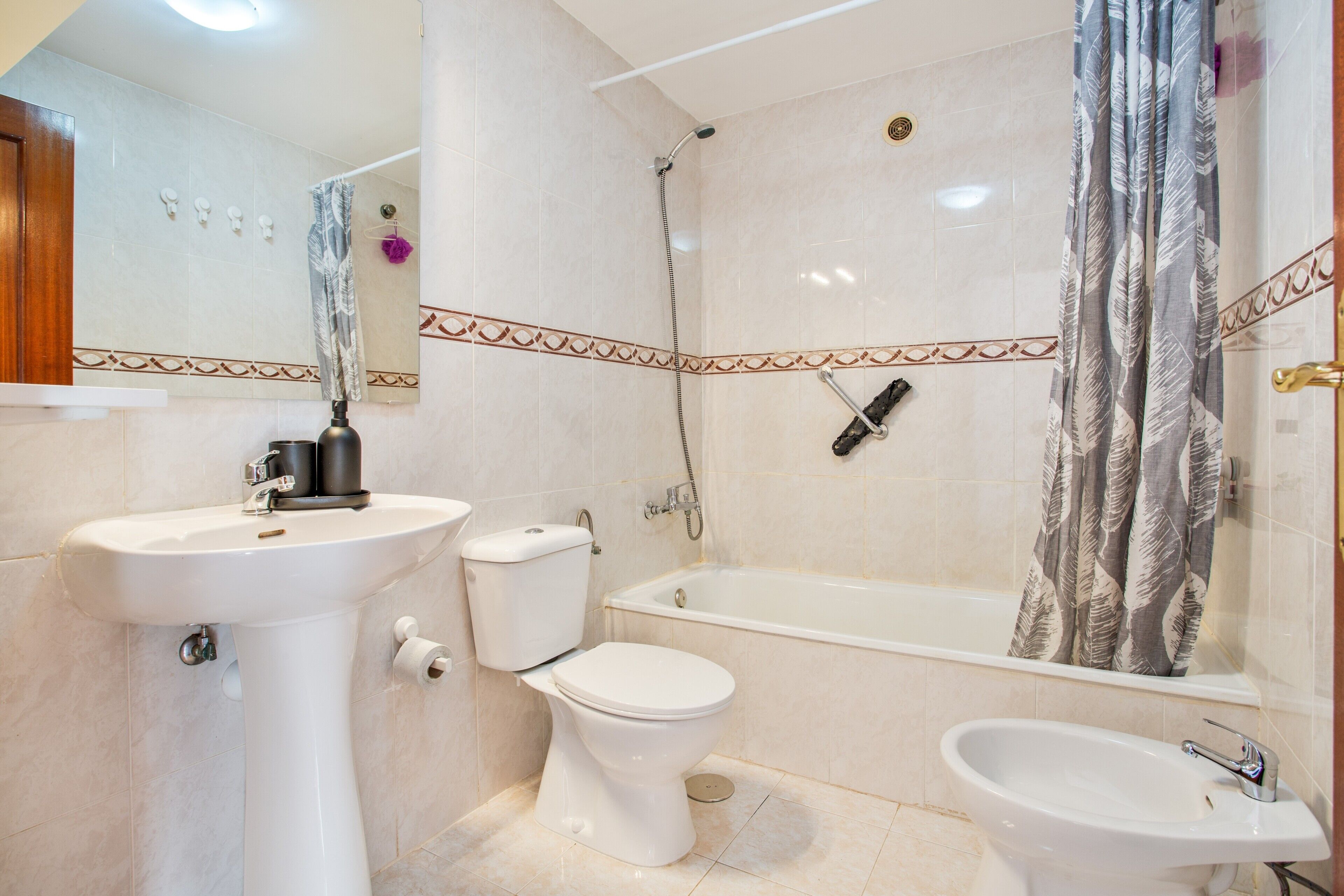 A bathroom with a toilet, sink, and bathtub.