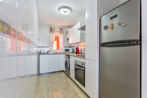 Une cuisine moderne équipée d’un réfrigérateur en acier inoxydable, d’un lave-linge, d’un four à micro-ondes et d’un grille-pain.