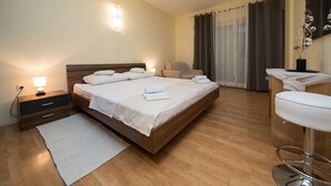 A hotel room with a large bed, bedside tables, a desk, and a chair. - Idyllic apartment with pool, table tennis, summer kitchen, private parking (Crikvenica)