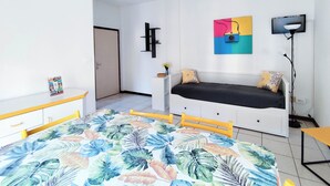 A modern bedroom with a bed, a desk, a chair, a TV, and a painting on the wall. - Cozy Flat by the Beach (Jesolo)