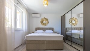 Un dormitorio con cama, armario y un espejo grande.