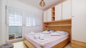 Ein Schlafzimmer mit Bett, Kleiderschrank, Schreibtisch und Stuhl.