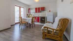 Un espace de vie compact comprenant un coin repas, une cuisine et un canapé.