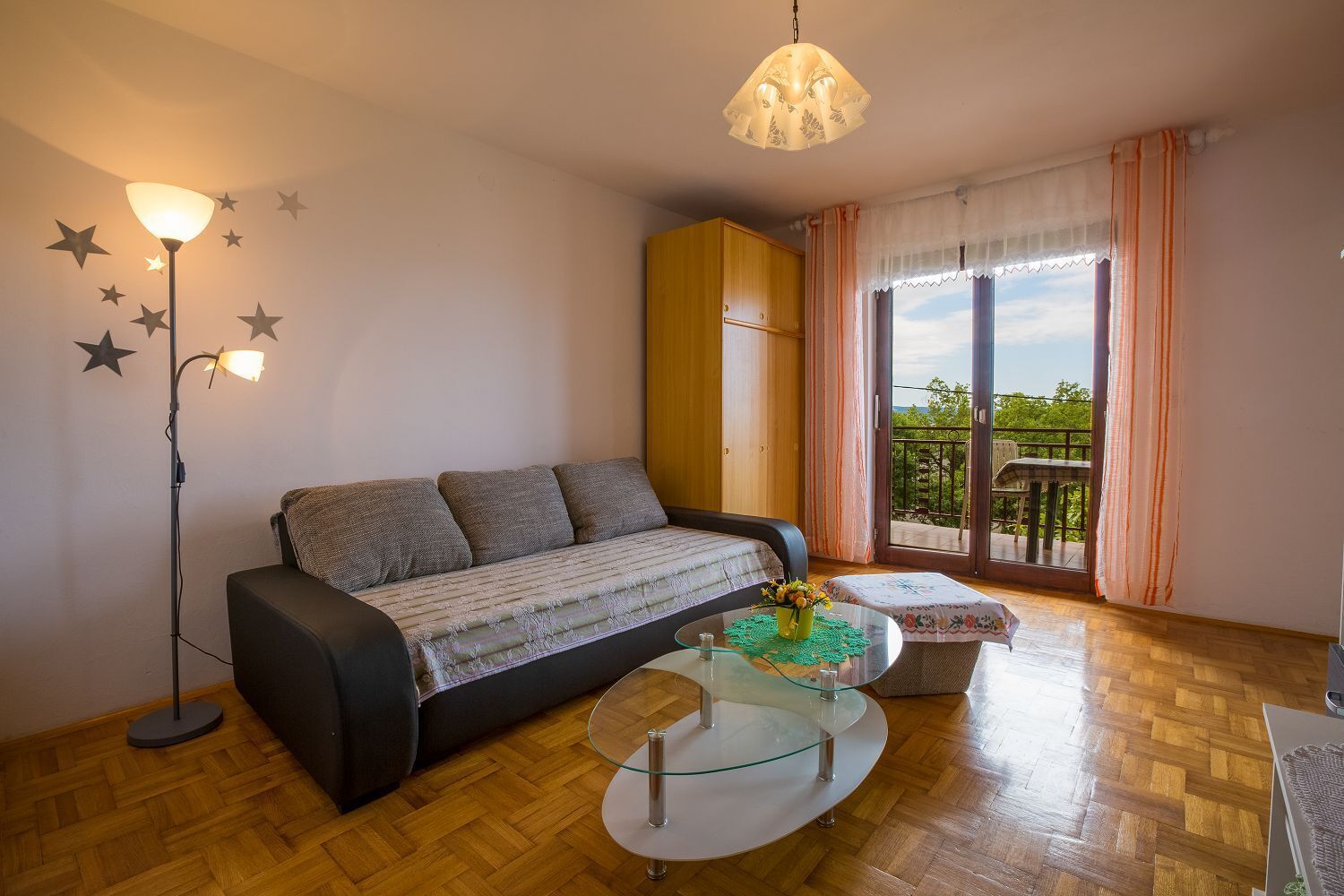 A cozy living room with a sofa, a glass coffee table, and a floor lamp.