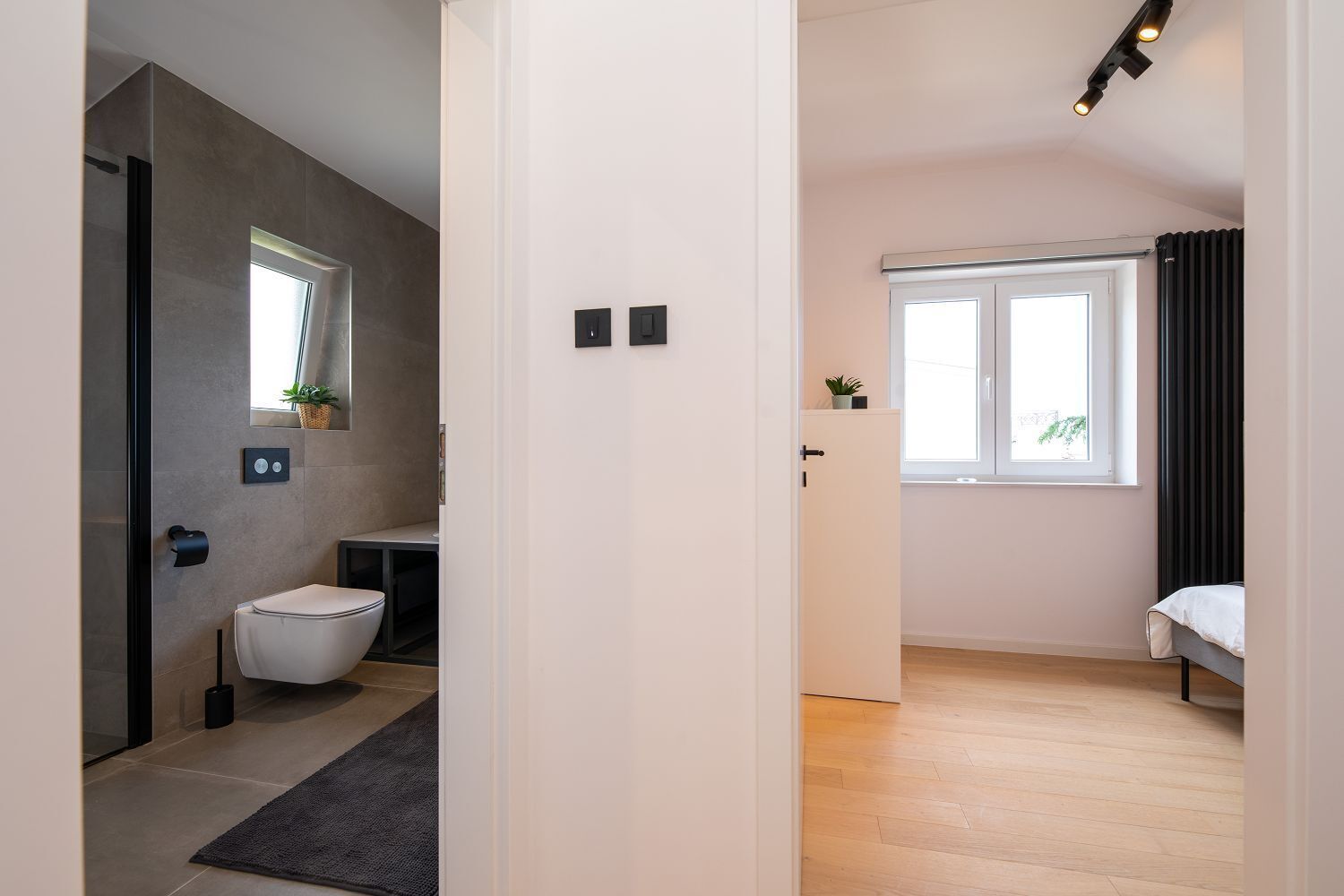 A modern bathroom with a toilet, sink, and shower area.