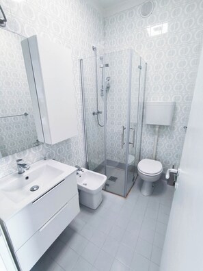 A modern bathroom with a glass-enclosed shower, a white sink, and a toilet. - Apartment With Balcony and Pool Access (Jesolo)