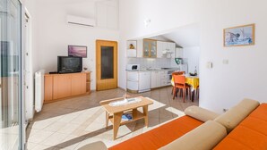 Un espacio habitable compacto con kitchenette, comedor y sofá.