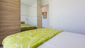 Ein Schlafzimmer mit einem Bett, einem Holzschrank und einem Spiegel.