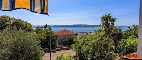 A coastal view with a building, trees, and a clear sky.