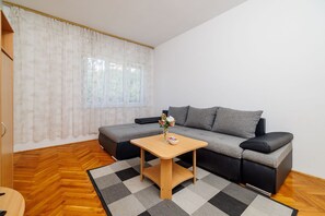 A modern living room with a grey sofa, a wooden coffee table, and a checkered rug. - Large apartment just 400 metres from the beach with sea view, barbecue area, WiFi, air conditioning (Crikvenica)