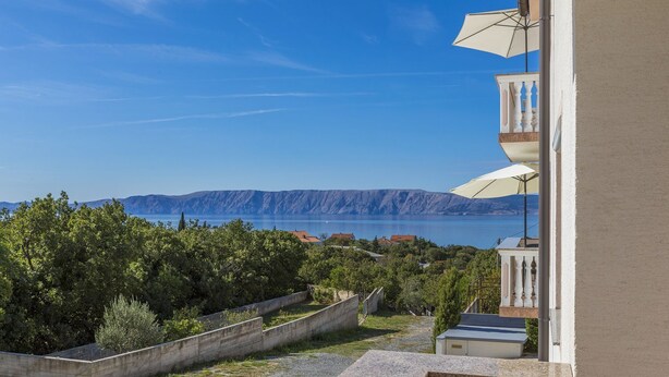 Een balkon met uitzicht op een meer en bergen.