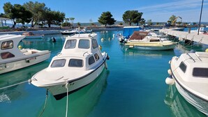 A marina with several boats docked, calm water, and trees in the background. - Dog-friendly studio apartment just 580 metres from the beach with parking space (Selce)