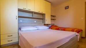 Ein Schlafzimmer mit einem Bett, einem Kleiderschrank und einem kleinen Nachttisch.