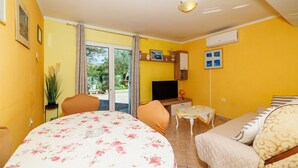 Een kamer met een bed, een televisie, een klein tafeltje en een bank.