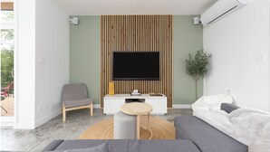 Una sala de estar moderna con un televisor de pantalla plana, un sofá gris, una mesa redonda de centro y un aparador blanco.