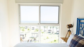 A bedroom with a large bed, a view of a beach, and a camera on a tripod. - Oceanfront Serenity -V5-3E- 2 bed, 2 bath (Punta Chame)