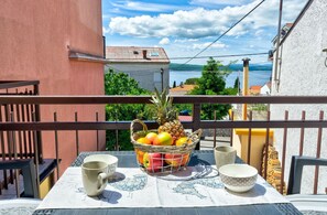 A balcony with a table set for two, featuring a fruit basket, two mugs, and a bowl. - Comfortable apartment just 300 metres from the beach with sea view, deckchair, barbecue (Crikvenica)