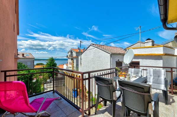 A balcony with a view of the sea, a table with chairs, and a satellite dish. - Comfortable apartment just 300 metres from the beach with sea view, deckchair, barbecue (Crikvenica)