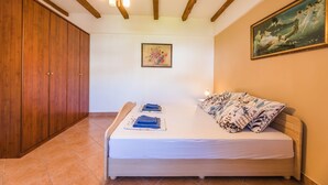 A bedroom with a bed, a wooden wardrobe, a painting, and a chandelier. - The perfect starting point for outdoor fun in Kvarner Bay (Bribir)