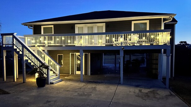 A two-story house with a balcony and a covered porch area. - About Time!
 Creekside Coastal Retreat 4BR/3BA in Emerald Isle with golf cart (Emerald Isle)