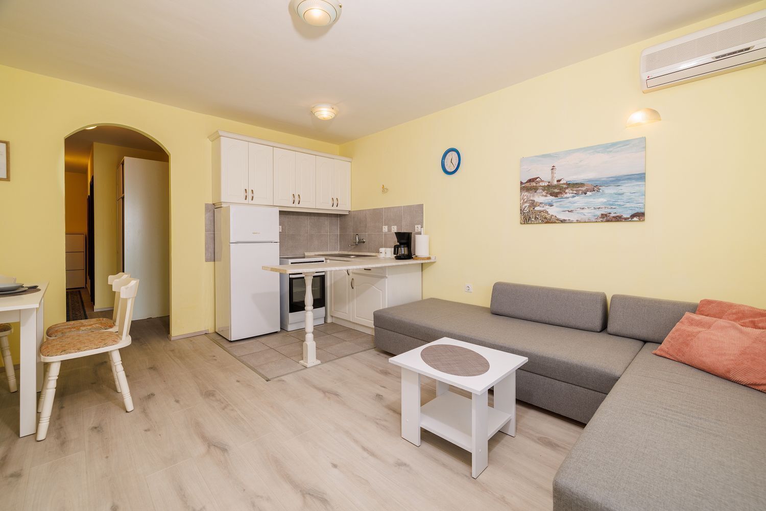 Een compacte leefruimte met een kitchenette, een eetgedeelte en een zithoek.