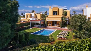 Ein Resort mit Swimmingpool, Sitzgelegenheiten im Freien und einer überdachten Terrasse.
