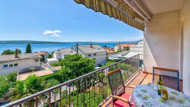 A balcony with a view of the sea and nearby buildings. - Bright apartment just 200 metres from the sandy beach with sea views (Crikvenica)