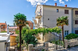 A two-story building with a stone staircase leading to a balcony. - Vintage-style apartment just 450 metres from the beach with sea views – dogs welcome (Crikvenica)