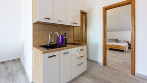 Een moderne keuken met een houten aanrecht, witte kastjes en een ingebouwd spoelbak.