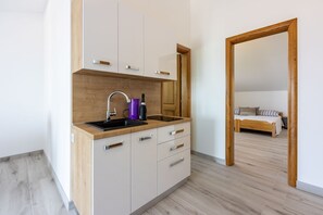 Eine moderne Küche mit einer Holz Arbeitsplatte, weißen Schränken und einer integrierten Spüle.
