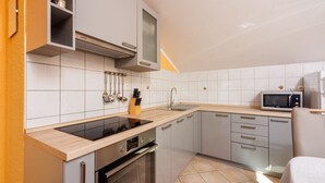 Cozinha moderna com fogão embutido, micro-ondas e pia.
