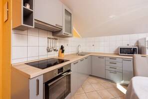 Eine moderne Küche mit Einbauherd, Mikrowelle und Spüle.