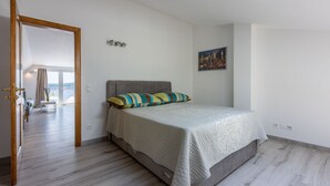 Une chambre à coucher avec un lit, une fenêtre et une porte donnant sur un balcon.
