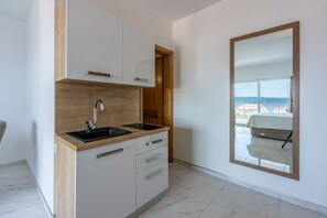 Une cuisine moderne dotée d’un évier à deux bacs, de meubles en bois et d’une grande fenêtre offrant une vue sur la ville.