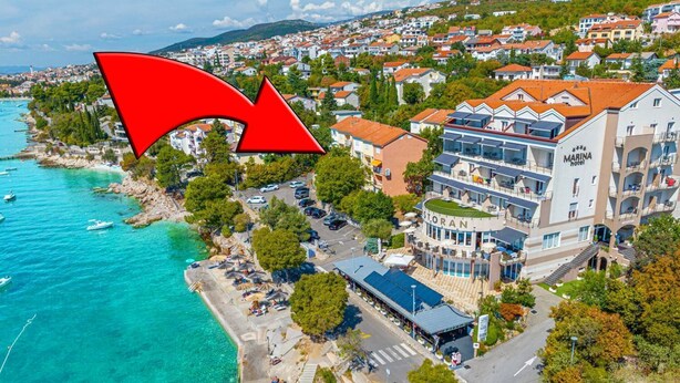Een kusthotel met een terras op het dak, een zwembad en uitzicht op zee.