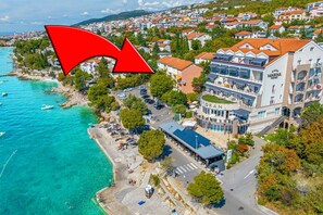 Um hotel à beira-mar com terraço no telhado, piscina e vista para o mar.