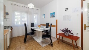 A dining area with a table, chairs, and a vase of flowers. - Dog-friendly apartment just 260 metres from the beach with sea views, barbecue (Dramalj)