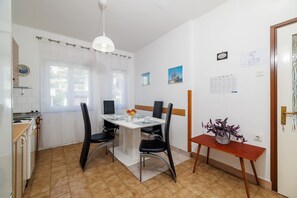 Ein Essbereich mit Tisch, Stühlen und einem Blumenstrauß.
