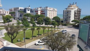 A residential area with a parking lot, trees, and buildings in the background. - Studio Apartment With Pool in Jesolo (Jesolo)