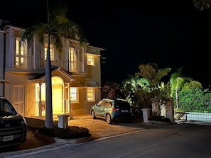 A two-story house with a driveway and parked cars. - Mullins Beach Villa - Luxury with Private Spa Pool (Battaleys Mews)