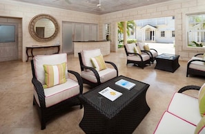 A spacious outdoor lounge area with wicker furniture and a large mirror on the wall. - Mullins Beach Villa - Luxury with Private Spa Pool (Battaleys Mews)