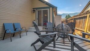 A patio with outdoor furniture, a sliding glass door entrance, and a view of a mountain range.