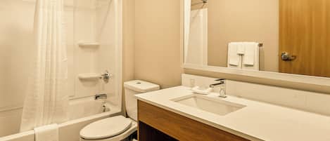 Een badkamer met een bad, toilet en wastafel.