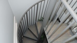 Un escalier en colimaçon au design moderne, combinant des éléments en métal et en bois.