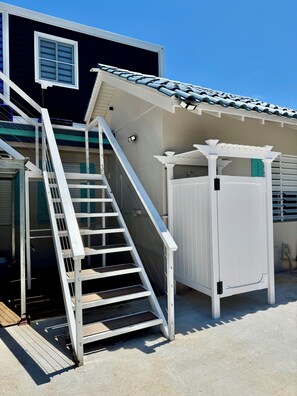 A residential building with a white exterior, a staircase leading to a balcony, and a covered outdoor area with a pergola. - Hotel boutique style Indoor and outdoor living n apart in Mar Chiquita with a/c (Manatí)