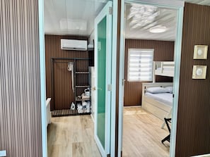 Una habitación con una cama individual superpuesta, un armario y un radiador.