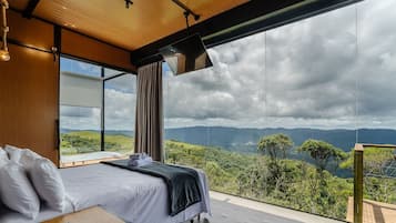 Un dormitorio con un ventanal que ofrece vistas a un paisaje montañoso.