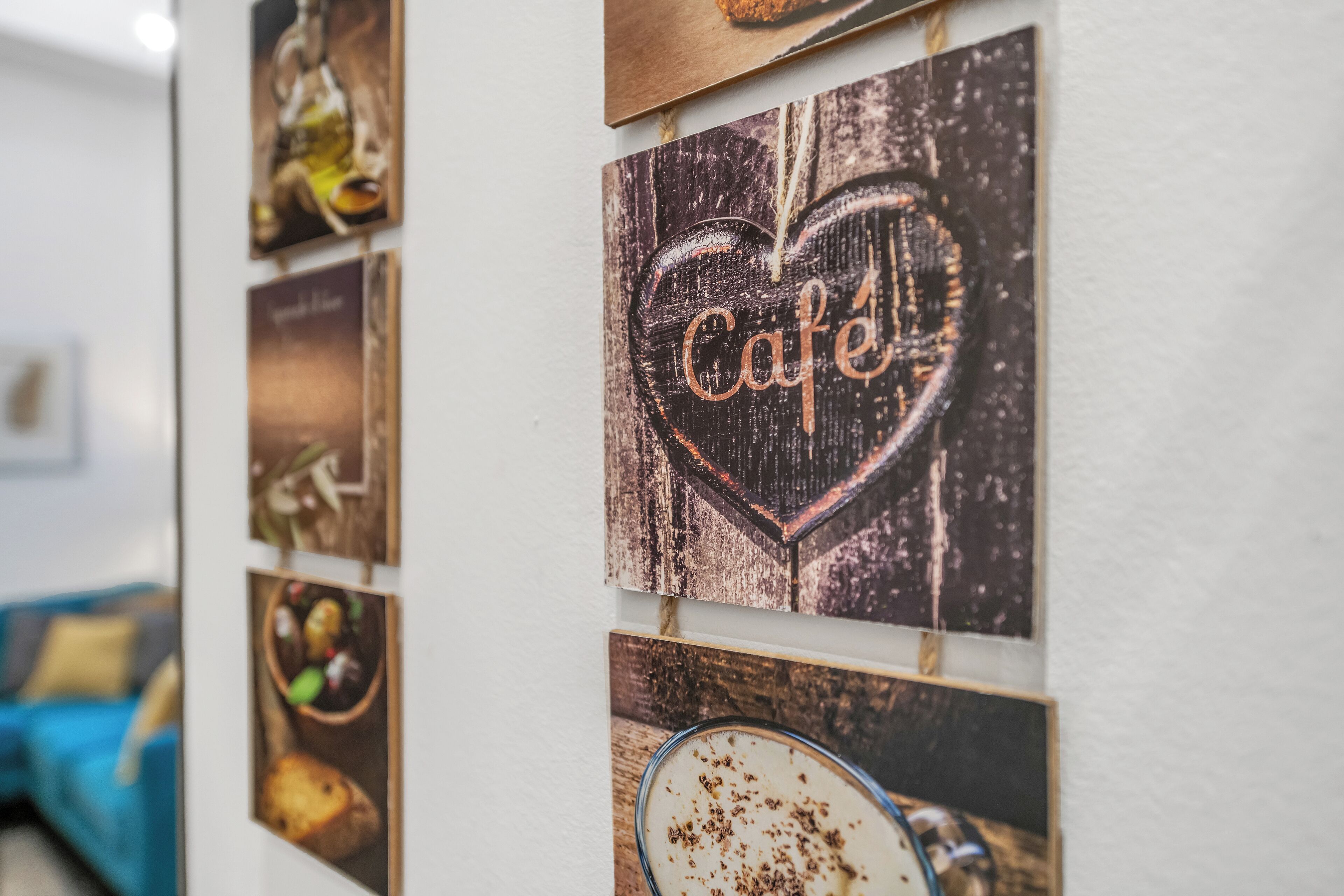 A wall with multiple framed pictures, including a prominent heart-shaped frame with the word "Cafe" and a picture of a dessert.