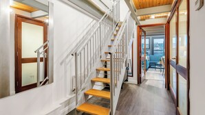 A modern staircase with wooden steps and metal railings, leading to a living area with a sofa and a coffee table. - Central Apt Old Market Sqr with Parking (Nottingham)