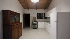 A kitchen with wooden cabinets, a stainless steel oven, and a white refrigerator.